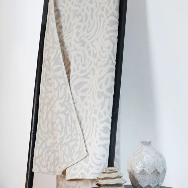 CARLA Throw "Floral Fine Lines" light grey — draped on a ladder rack