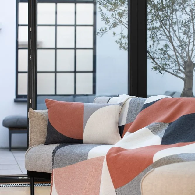 LUCA Throw "Modular Forms" copper/charcoal — styled over a sofa