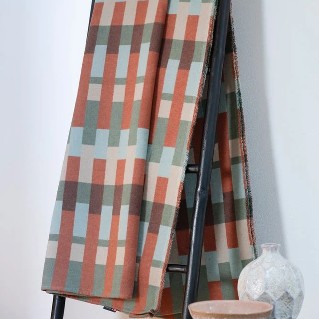 LUCA Throw "Patchwork" green — draped on a ladder rack