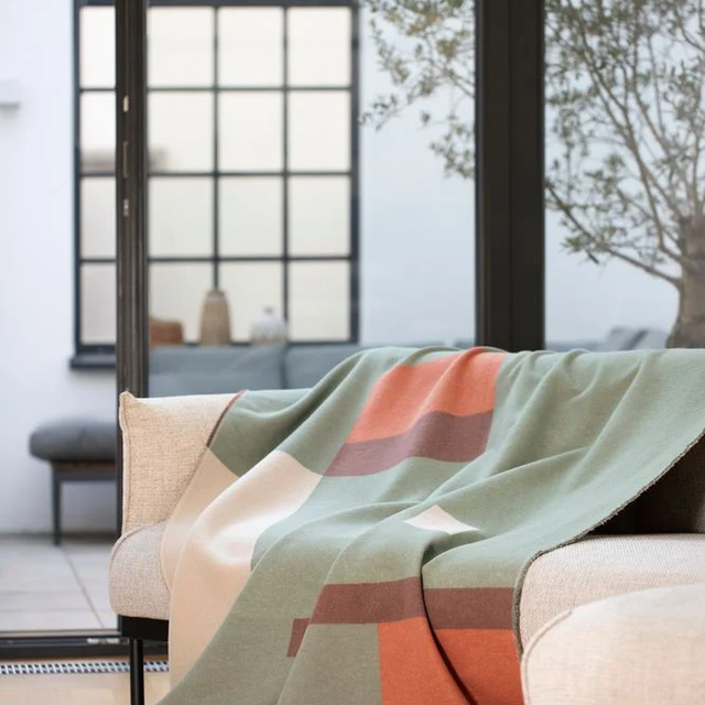 LUCA Throw "Squares" green — styled over a sofa